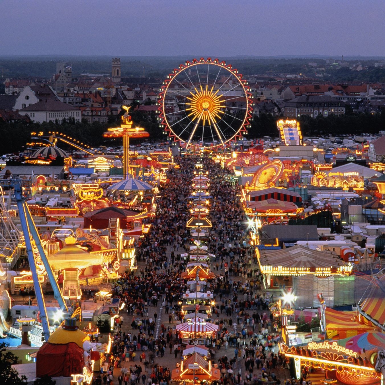 Oktoberfest München mit beleuchtetem Riesenrad am Abend